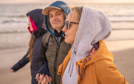 Family with daughter walking on the coastの写真素材