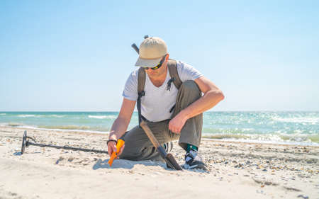 Senior man with metal detector and shovel searching jewelryの写真素材