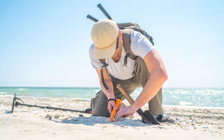Man digging sand when found something with metal detectorの写真素材