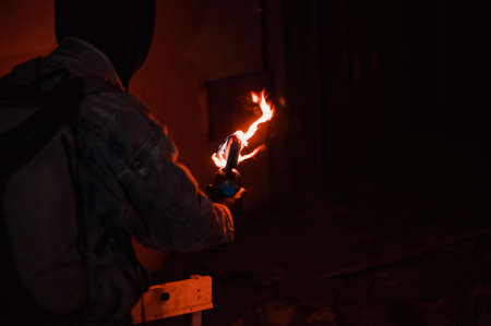Protester burn molotovs cocktail preparing to throw. Dangerous photo of true life protestの写真素材