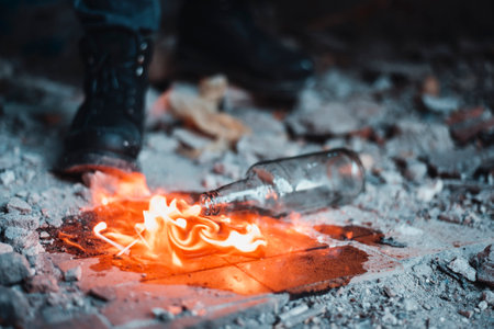 Puddle of flaming gas near the bottle. misadventure with Molotovs cocktail in time of preparing, Dangerous situation.の写真素材