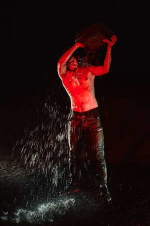 Strong young man uses canister with gasoline to drench himself and burn. Preparing for a self-immolationの写真素材