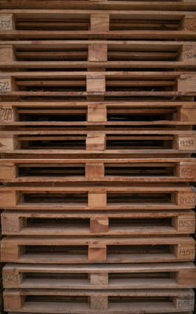 Wooden pallets for industrial and transport stacked in a large column on a warehouseの写真素材