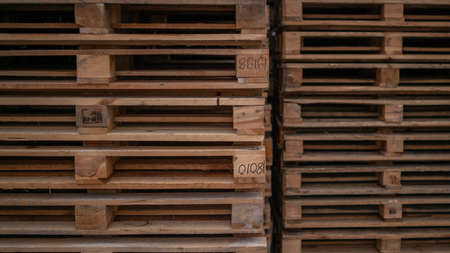 Wooden pallets for industrial and transport stacked in a large column on a warehouseの写真素材
