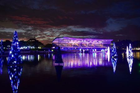 Orlando, Florida; November 15, 2018. Illuminated Christmas Tree over the lake and colorful stadium on sunset background in International Drive area.のeditorial素材