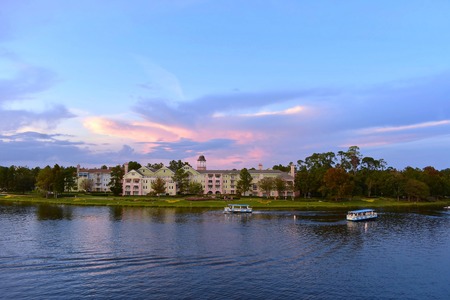 Orlando, Florida. November 24, 2018 at Lake Buena Vista. Ferry boats and victorian style hotel on colorful sunset background in Lake Buena Vista.のeditorial素材