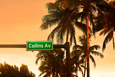 Miami Beach, Florida. January 05, 2018 Collins Ave. sign and palms trees on colorful sunset background.のeditorial素材