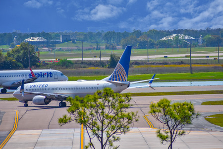 Orlando, Florida. March 01, 2019. Spirit Airlines and United Airlines aircraft on the run from Orlando International Airport (MCO). (3)のeditorial素材