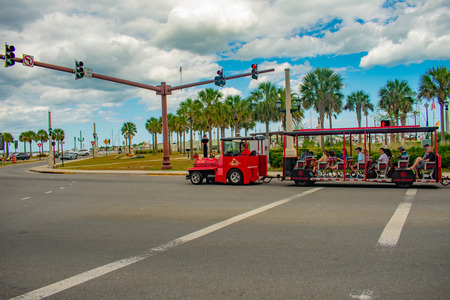 St. Augustine, Florida. March 31, 2019. Red Train Tour and palm trees in Florida's Historic Coast.のeditorial素材