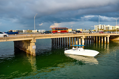 Clearwater Beach, Florida. January 25, 2019 Colorful Jolley Trolley and bowrider boat crossing the Gulf Coast Beaches.のeditorial素材
