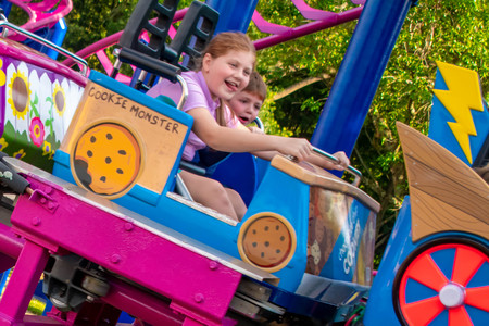 Orlando, Florida. April 7, 2019. Beautiful girl and nice little boy enjoying Cookie Drop rollercoaster at Seaworld in International Drive area.のeditorial素材