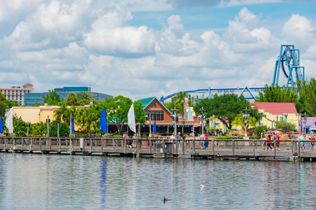 Orlando, Florida. April 7, 2019. People walking on wood bridge. View of colorful dockside and Manta Ray rollercoaster at Seaworld in International Drive area (1)のeditorial素材