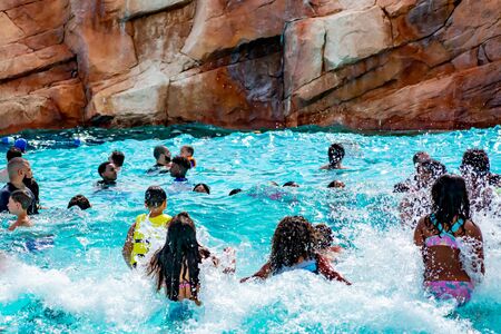 Orlando, Florida. April 07, 2019. Parents and kids having fun pool on bluelight water at Aquatica (5)のeditorial素材