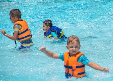 Orlando, Florida. May 20, 2019. Little boys playing with artificial waves at Aquatica in International Drive area (1)のeditorial素材