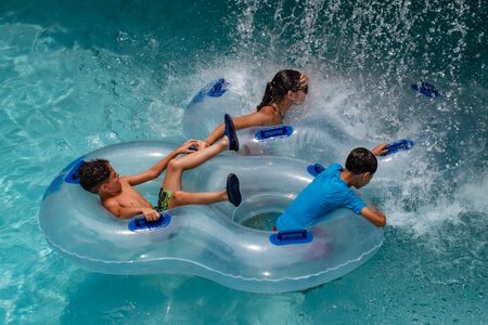 Orlando, Florida. July 01, 2019. Mother and kids enjoying water fall on lazy river at Aquatica.のeditorial素材