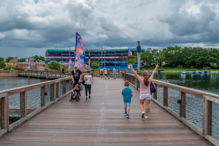 Orlando, Florida. June 17, 2019. Nice girl raising her arms while walking with her family at...