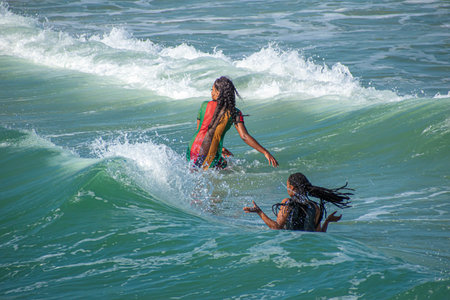 Daytona Beach Florida. July 07, 2019 Girl and boy with surfboard enjoying waves at Main Street Pier...