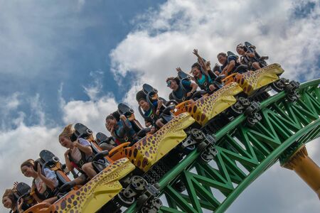 Tampa Bay, Florida. August 08, 2019. People having fun terrific Cheetah Hunt rollercoaster on lightblue cloudy sky background 66のeditorial素材