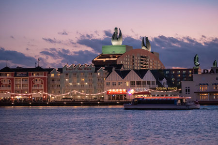 Orlando, Florida. October 11, 2019. Taxiboat sailing on blue lake on colorful illuminated buildings...