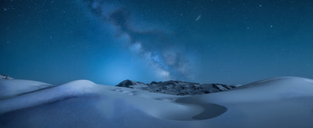 Starry sky and milky way over snowy mountain peak, panoramaの素材