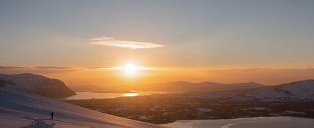 Panoramic view of sunset over the snow-covered mountains.の素材