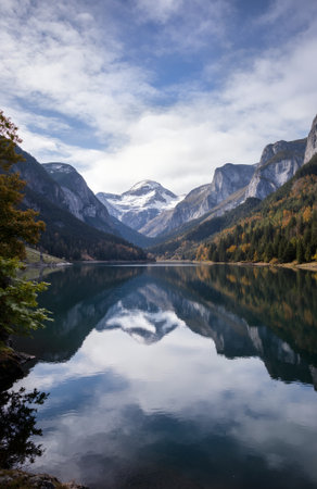 Autumn alpine lake with reflection of mountains and clouds in the waterの素材