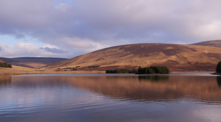 Lake with reflection of mountains in the water, Scotland, UK.の素材