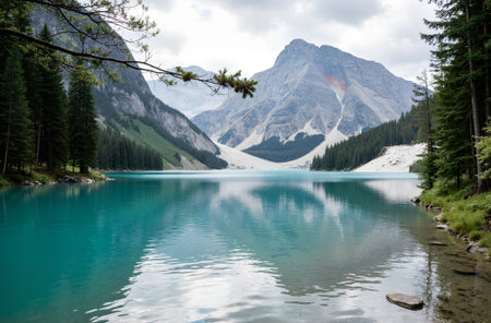 Beautiful turquoise lake with reflection of mountains and clouds in the waterの素材