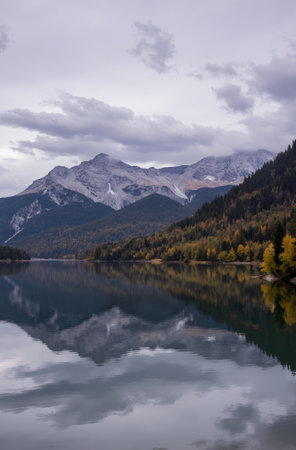 Autumn alpine lake with snow-capped mountains in backgroundの素材