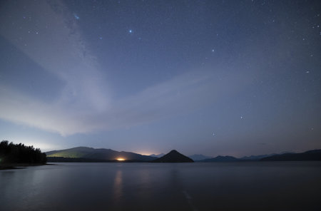 Milky Way over the lake at night with mountains in the backgroundの素材