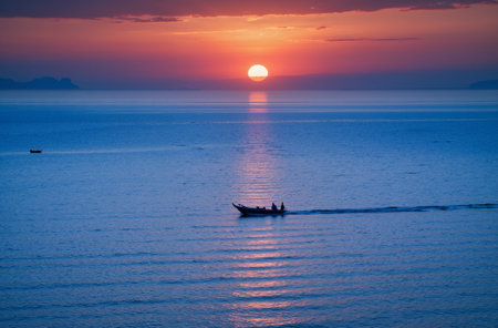 Silhouette of fishing boat in the sea at sunset background.の素材