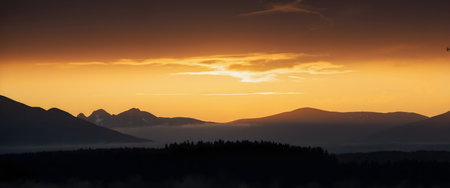 Sunset in the mountains. Panoramic view of the mountain range.の素材