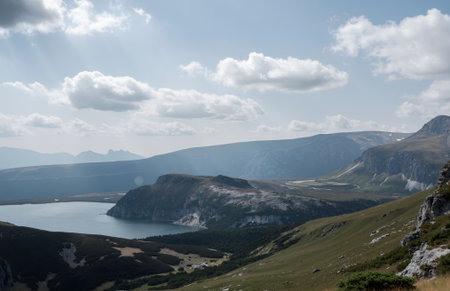 Mountain landscape with lake and blue sky with sunbeams.の素材