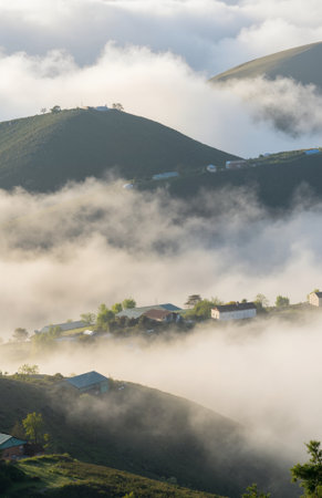 Morning fog over the village in the mountains, Carpathians, Ukraineの素材