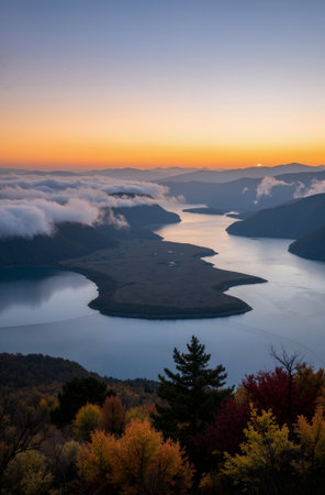 Autumn landscape with lake and mountains in the fog at sunset.の素材