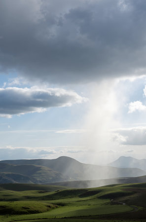 Sun rays in the clouds over the rolling hills of the Azoresの素材