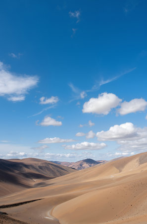 Desert landscape with blue sky and white clouds in the background.の素材