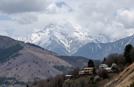 Alpine village with snow mountain in background. Caucasus Mountains, Georgia.の素材