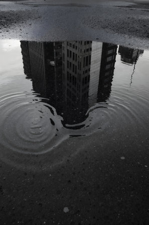 Reflection of a building in a puddle in New York Cityの素材