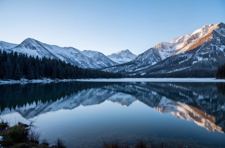 Beautiful winter landscape with snow-capped mountains reflected in the lakeの素材