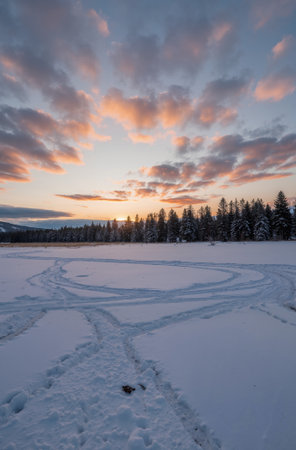 Beautiful winter landscape with snow covered trees and a road at sunsetの素材