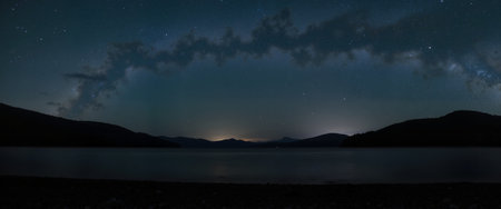 Milky Way over a lake with mountains in the background. Long exposureの素材