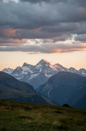 Mountain landscape with snow-capped peaks at sunset in summerの素材