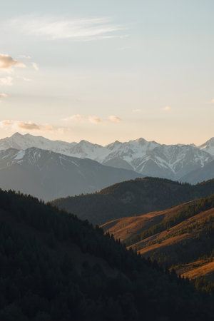 Mountain landscape with snow-capped peaks in the evening.の素材