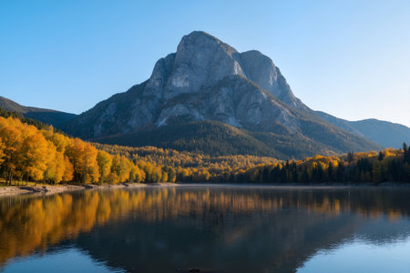 Autumn alpine lake with reflection of mountains and blue sky.の素材