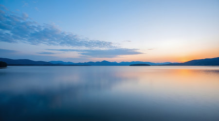 Beautiful sunset on the lake with mountains and clouds in the backgroundの素材