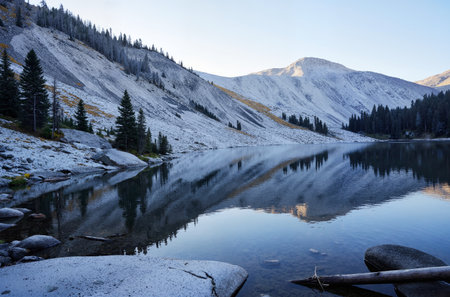 Mountain lake with snow and reflection in the water at sunset.の素材
