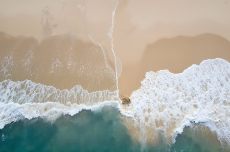 Aerial view of a rocky beach with turquoise water and white foamの素材