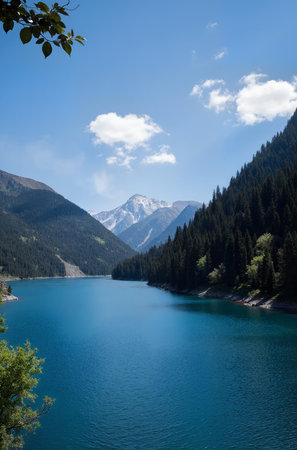 Lake in the mountains with blue sky and white clouds in the backgroundの素材