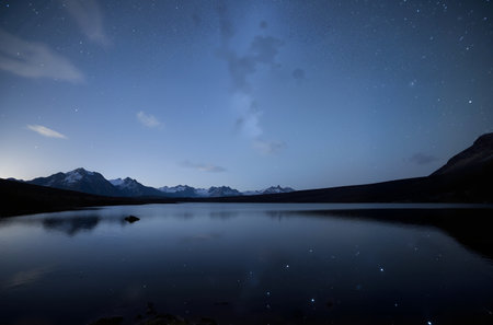 Night landscape with starry sky and reflection of mountains in the lakeの素材